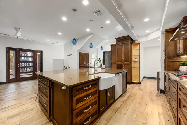 a large kitchen with stainless steel appliances granite countertop a large counter top a stove and a wooden floors