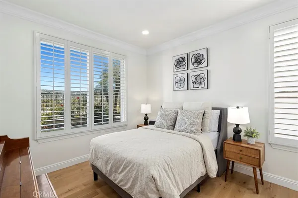 a large bedroom with a bed and wooden floor