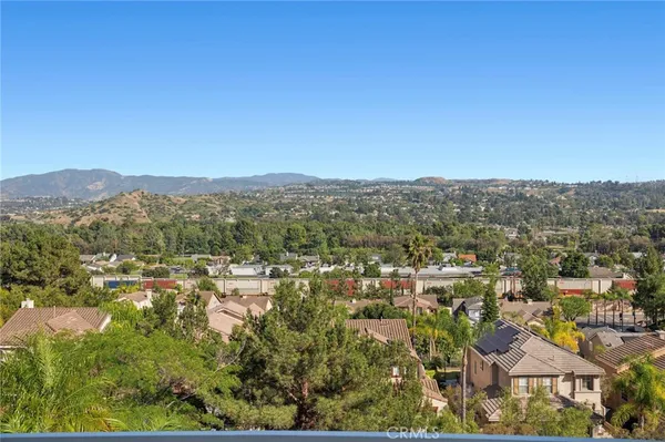 an aerial view of residential houses with outdoor space and trees