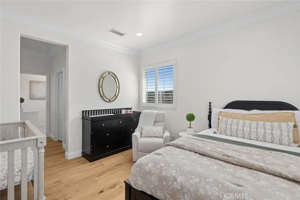 a bedroom with a bed a mirror and a window