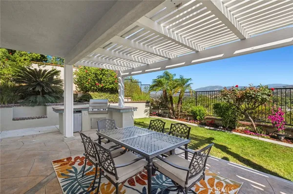 a view of a patio with table and chairs potted plants with wooden floor and fence