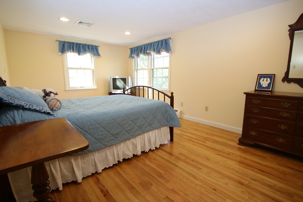 165 Herrick Road Boxford, MA 01921 - Photo 24 of 30 a bedroom with a bed and wooden floor