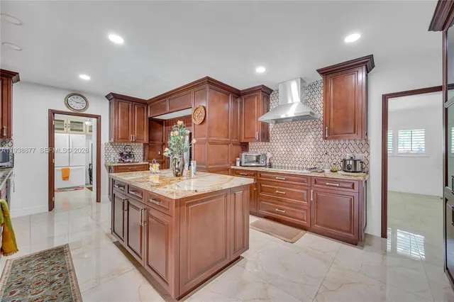 a kitchen with kitchen island granite countertop a sink and refrigerator