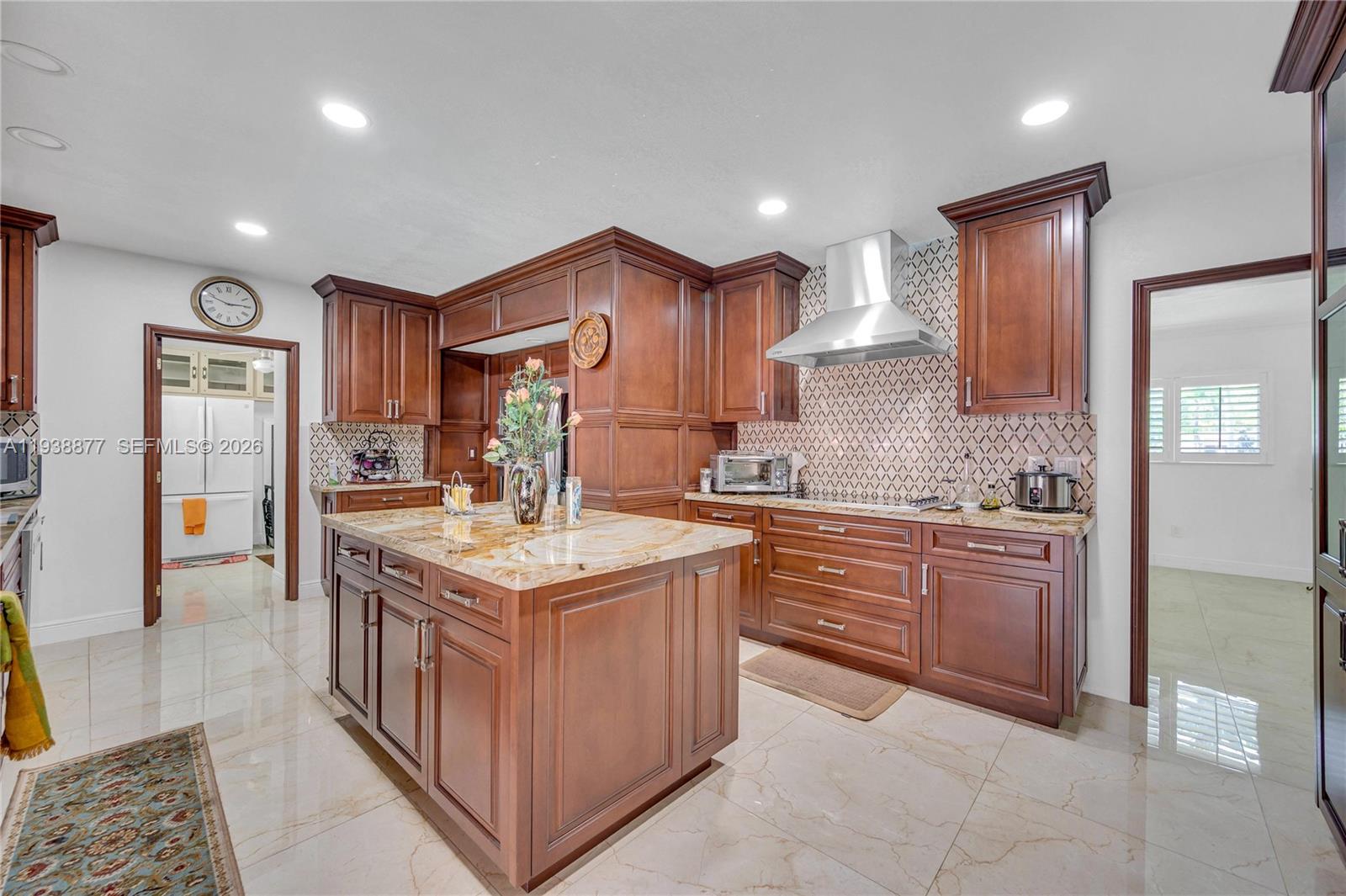 110 Shore Drive West Miami, FL 33133 - Photo 17 of 40 a kitchen with kitchen island granite countertop a sink and refrigerator