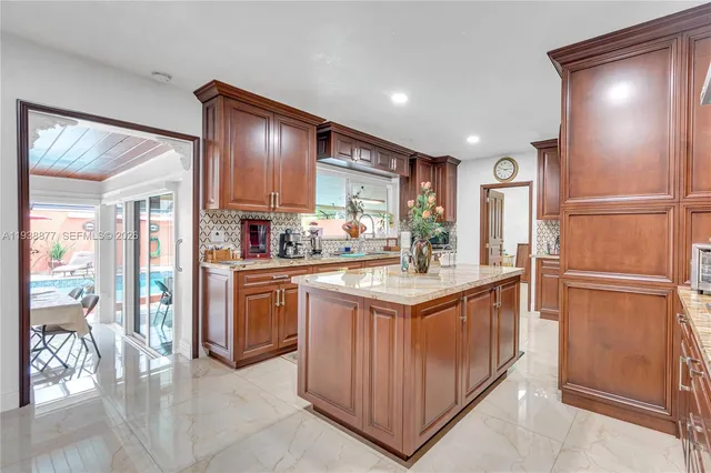 a kitchen with kitchen island granite countertop wooden cabinets and white appliances