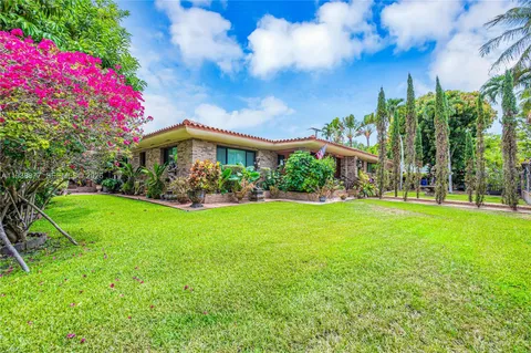 a view of a house with a big yard and a large tree
