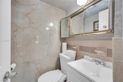 a bathroom with a sink mirror and toilet