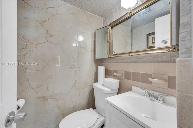 a bathroom with a sink mirror and toilet