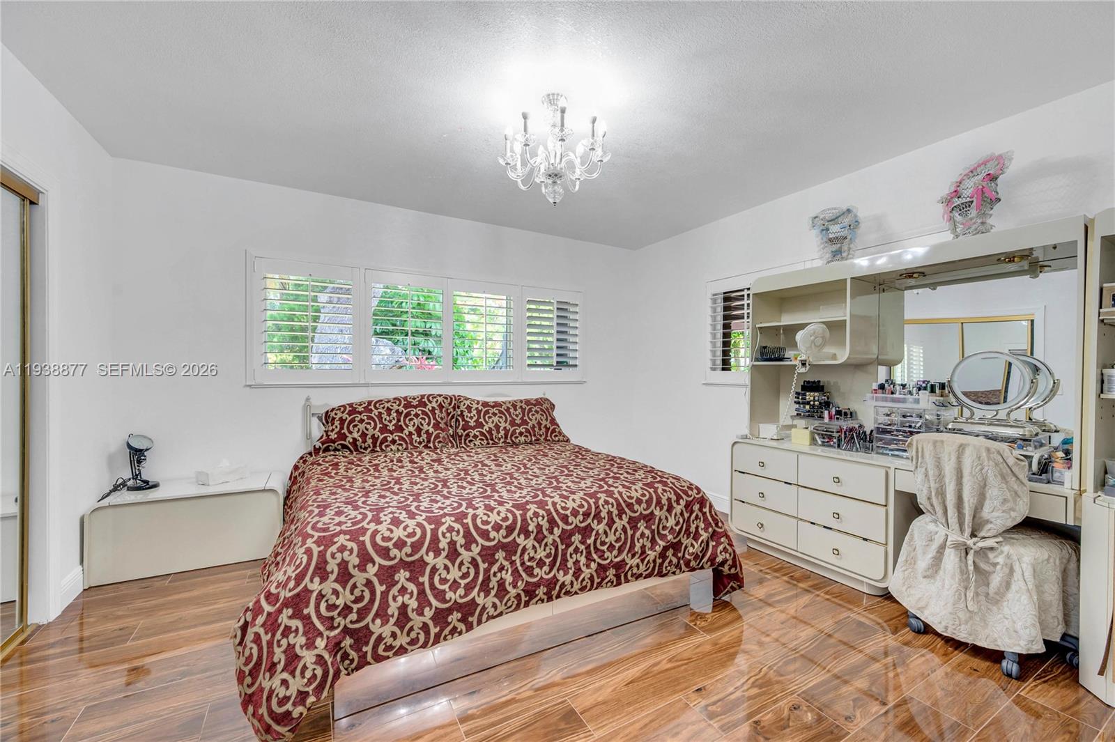 110 Shore Drive West Miami, FL 33133 - Photo 26 of 40 a bedroom with a large bed and a chandelier