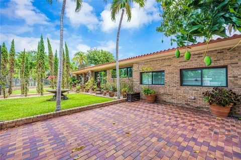 a view of a house with backyard and sitting area
