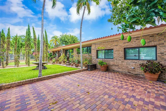 a view of a house with backyard and sitting area