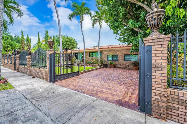 a view of a house with a yard and potted plants