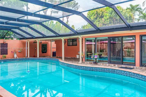 a house view with swimming pool in front of it