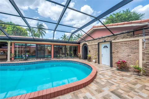 a view of a house with pool fire pit and chairs in patio