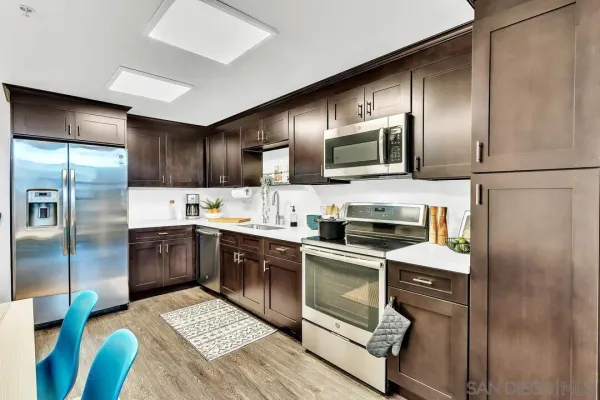a kitchen with granite countertop stainless steel appliances and wooden cabinets