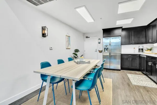 a kitchen with a table chairs refrigerator and microwave