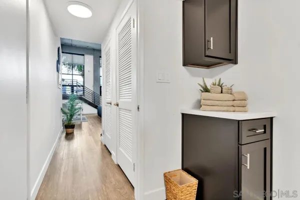 a view of a hallway with wooden floor and a cabinet