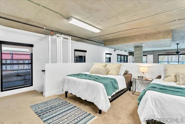 a spacious bedroom with a bed a couch and cabinet