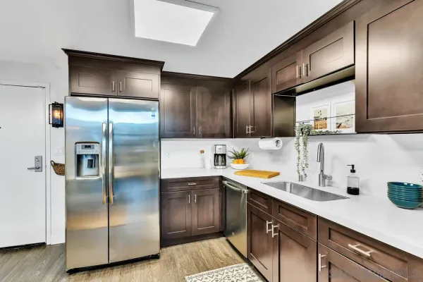 a kitchen with kitchen island granite countertop stainless steel appliances a sink and cabinets