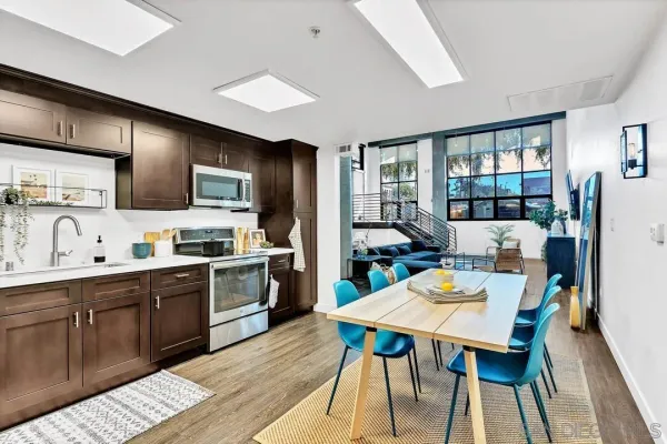 a large kitchen with cabinets wooden floor and stainless steel appliances