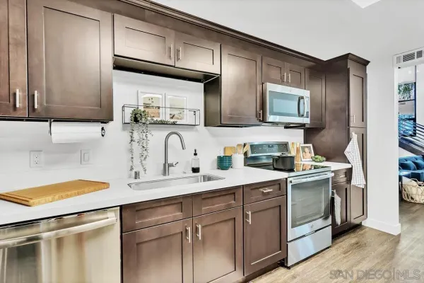 a kitchen with stainless steel appliances granite countertop a sink stove and cabinets
