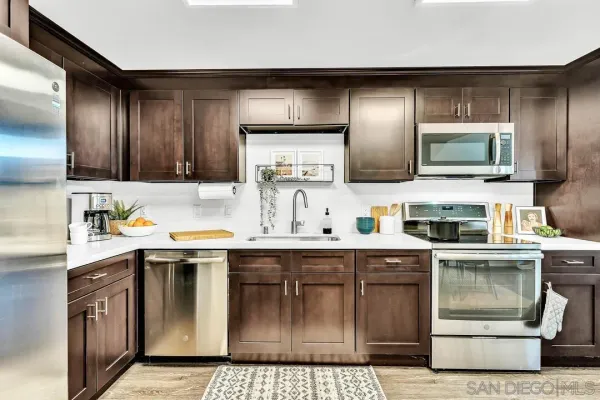 a kitchen with stainless steel appliances granite countertop a stove a sink and a microwave