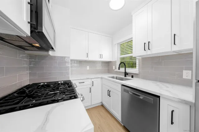 a kitchen with a sink a stove and cabinets