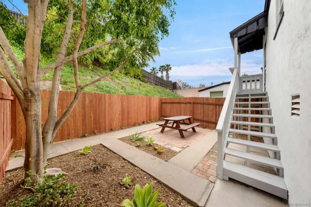a backyard of a house with table and chairs