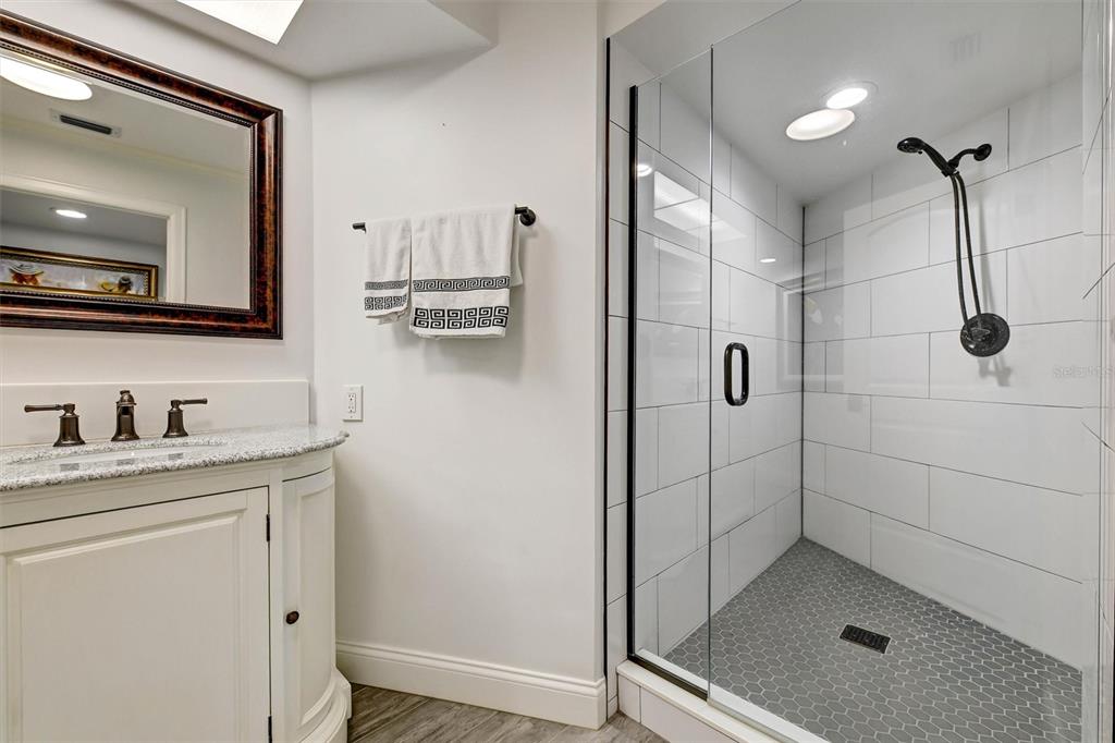 1875 Belleair Road Clearwater, FL 33764 - Photo 51 of 100 a bathroom with a granite countertop sink a mirror and shower
