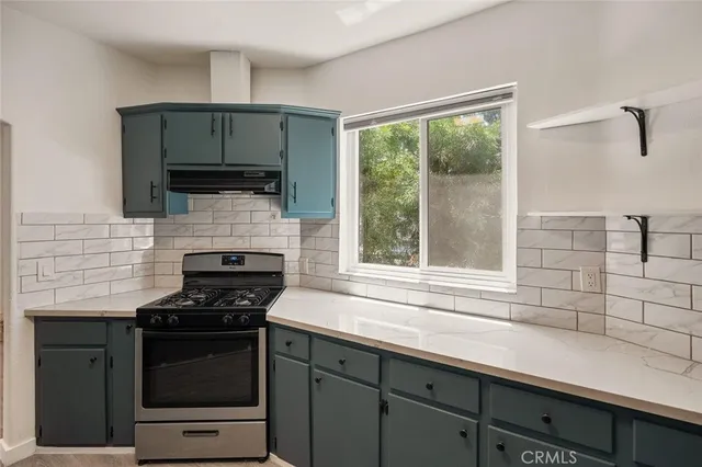 a kitchen with a sink stove top oven and cabinets