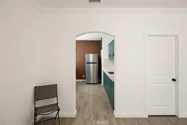 a view of a hallway with wooden floor and a cabinet