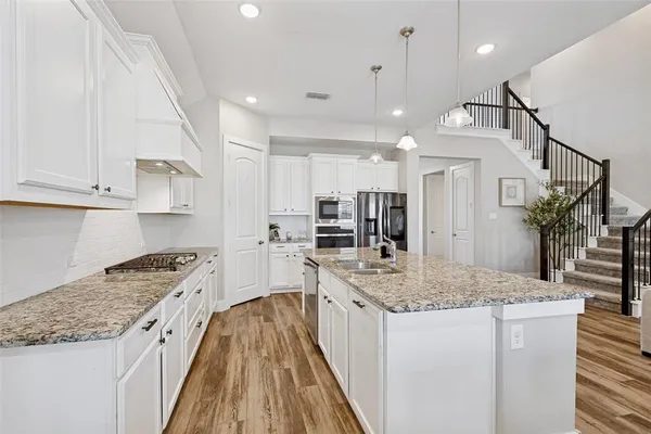 a kitchen with stainless steel appliances granite countertop a sink stove and refrigerator