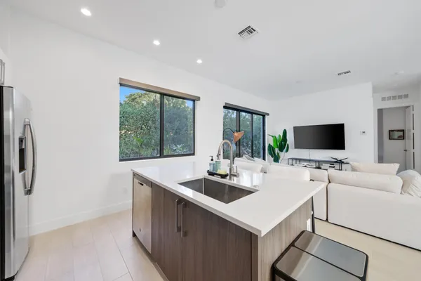 a kitchen with stainless steel appliances a stove a refrigerator a sink a stove and cabinets