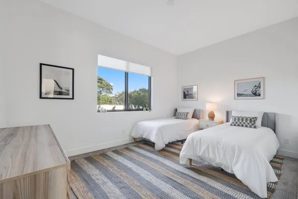 a bedroom with two beds and a potted plant
