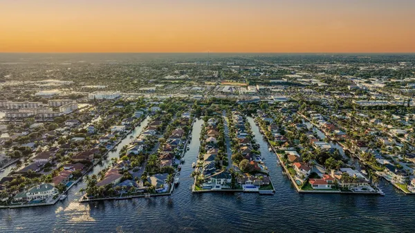 a front view of a house with garden and trees
