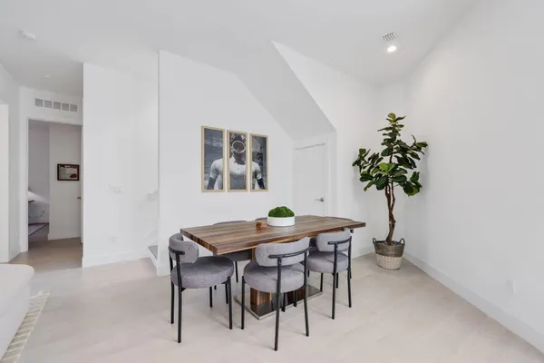 a kitchen with stainless steel appliances a table and chairs in it