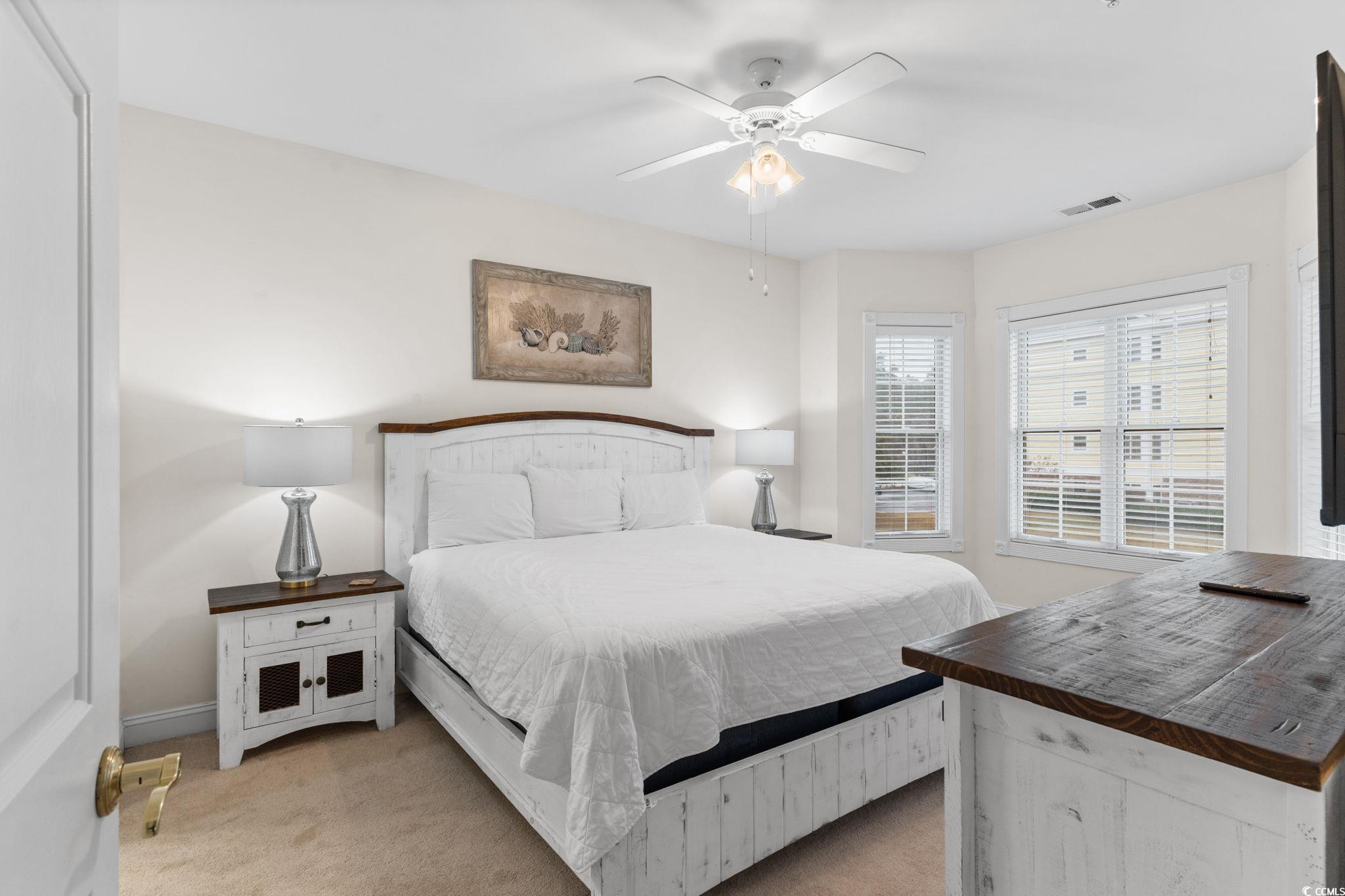 4843 Luster Leaf Circle, Unit 204 Myrtle Beach, SC 29577 - Photo 16 of 36 Bedroom featuring light colored carpet and ceiling fan