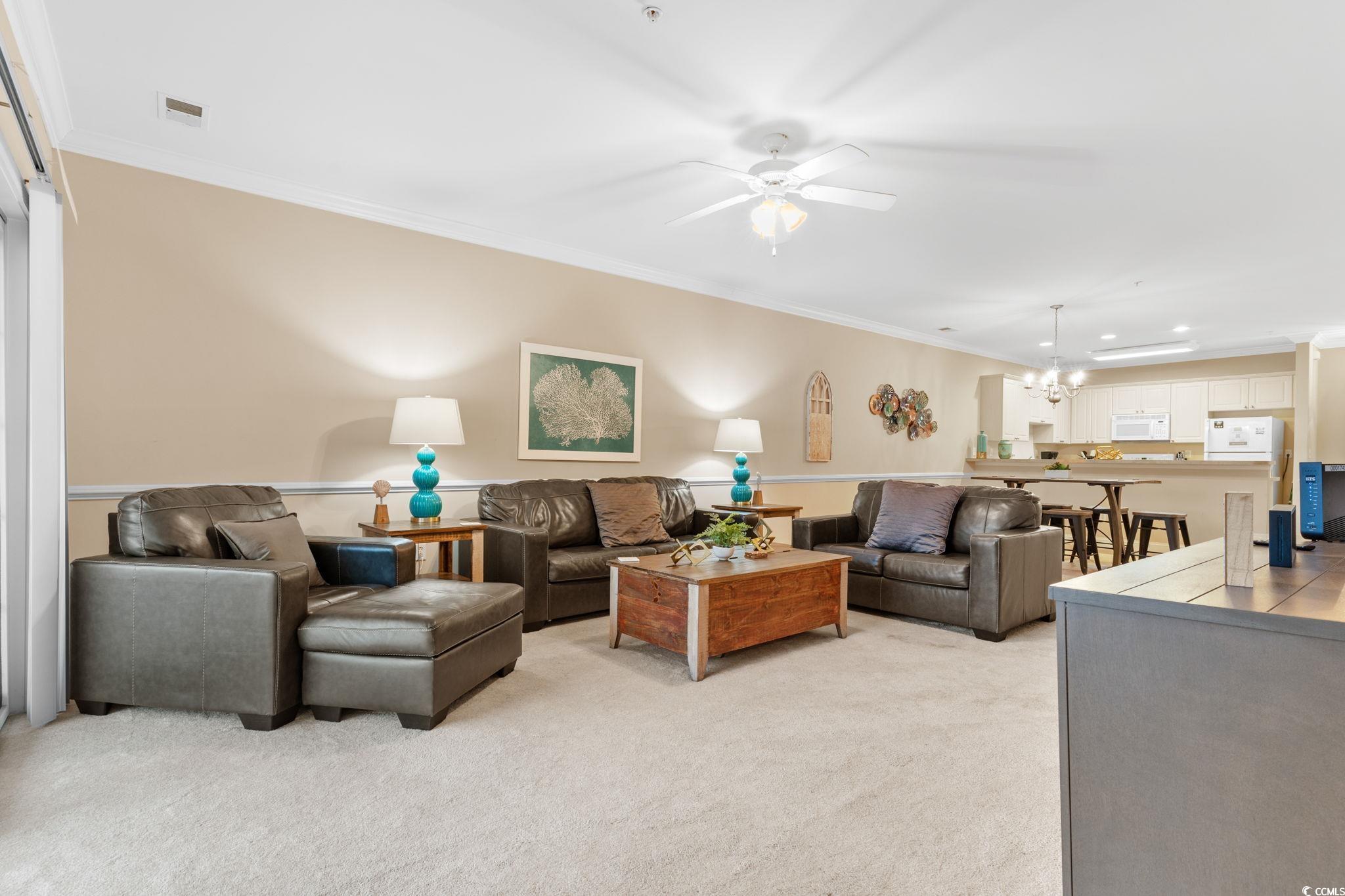 4843 Luster Leaf Circle, Unit 204 Myrtle Beach, SC 29577 - Photo 5 of 36 Living room with crown molding, a ceiling fan, light colored carpet, a chandelier, and recessed lighting