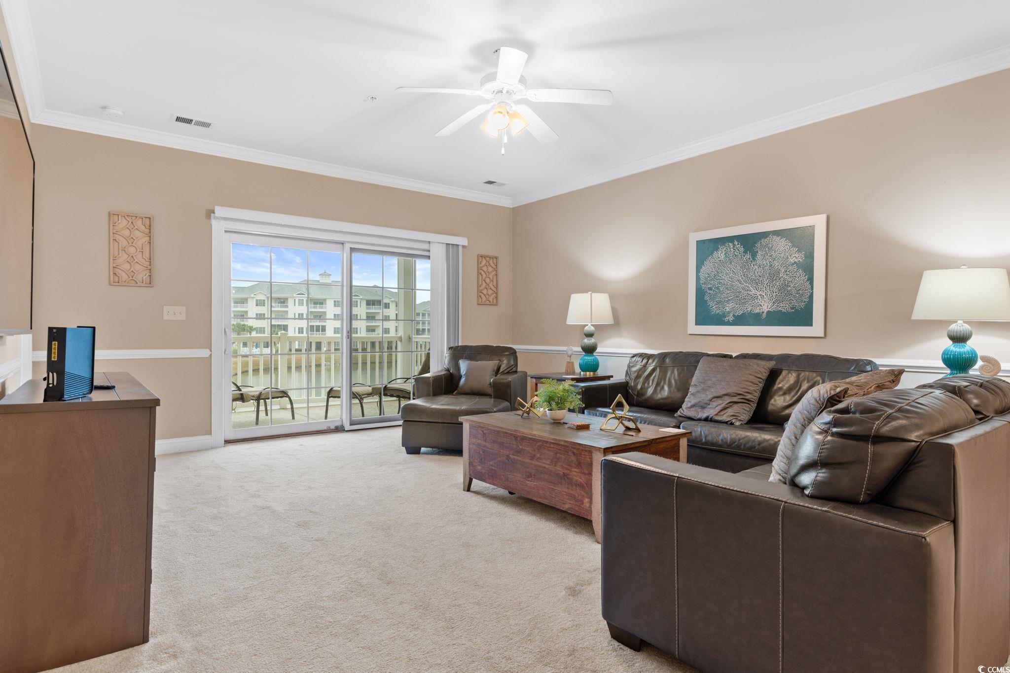 4843 Luster Leaf Circle, Unit 204 Myrtle Beach, SC 29577 - Photo 9 of 36 Living area with light colored carpet, crown molding, a water view, and a ceiling fan