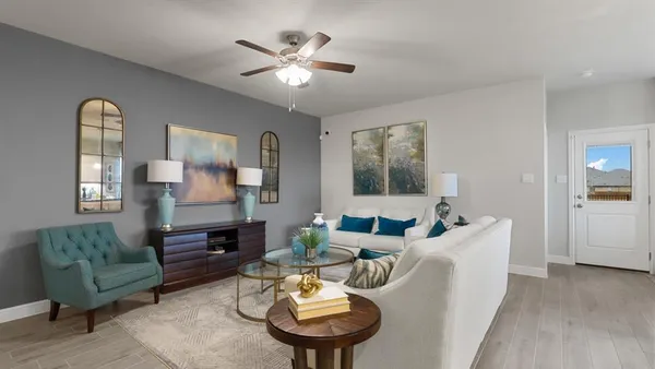 a living room with furniture kitchen view and a chandelier