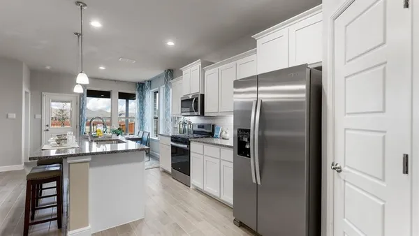 a kitchen with a sink microwave cabinets and refrigerator