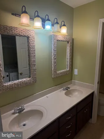 a bathroom with double vanity sink and a mirror