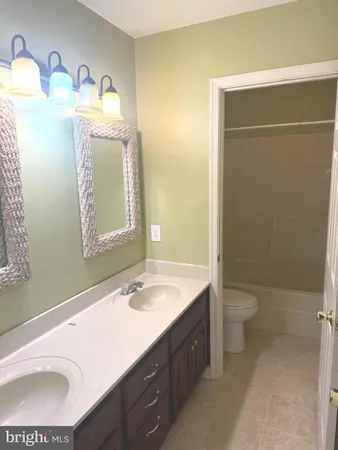 a bathroom with a sink a toilet and mirror