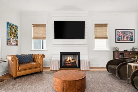 a living room with furniture a fireplace and a flat screen tv