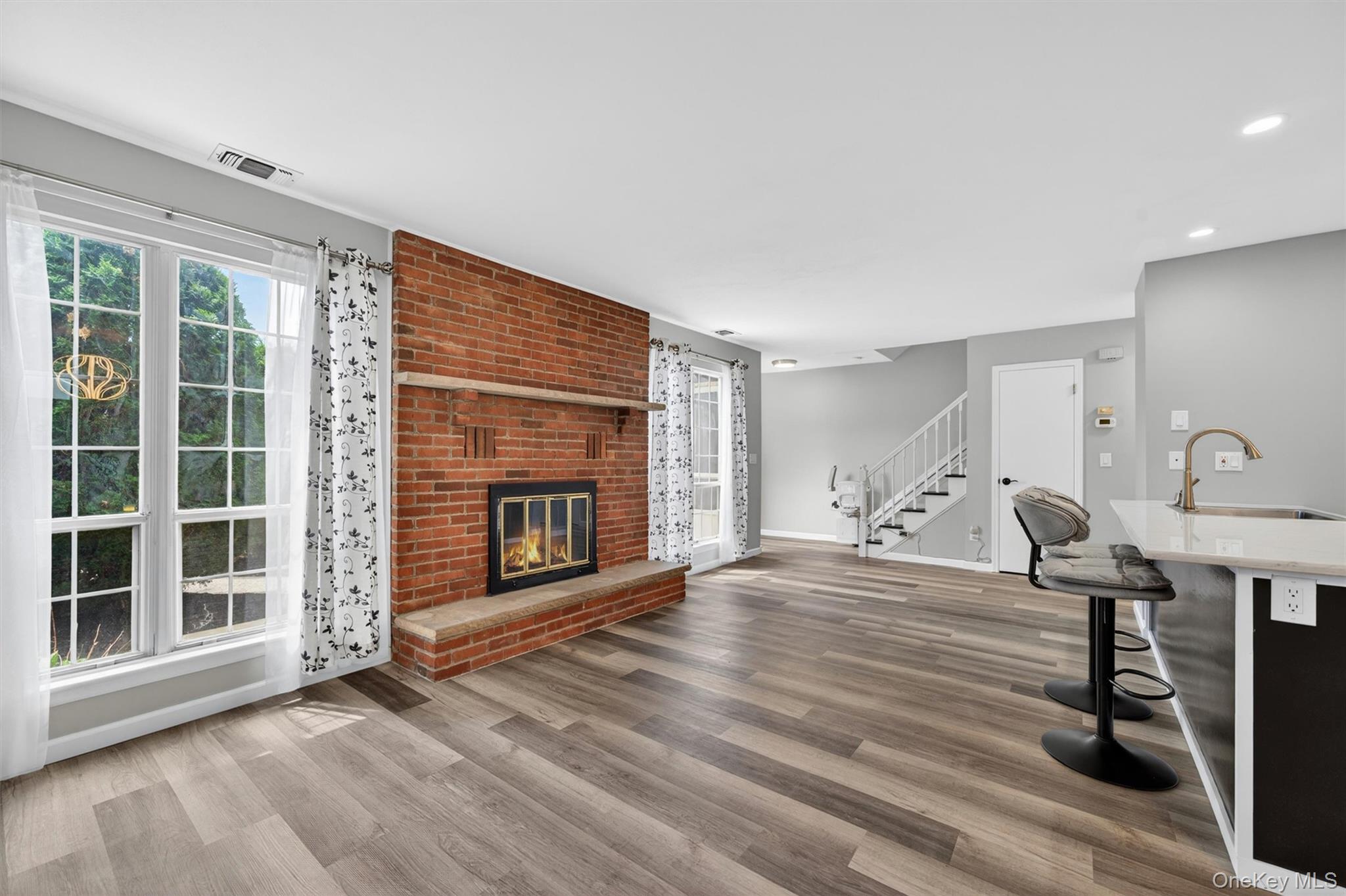 a view of empty room with wooden floor and fireplace