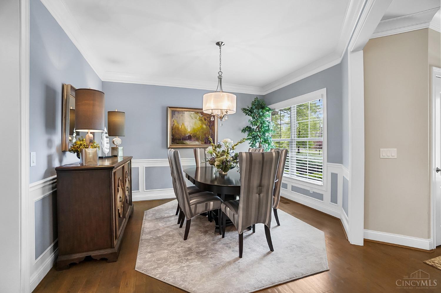 7105 Graves Road Cincinnati, OH 45243 - Photo 29 of 86 Formal dining room with chandelier, wainscotting and natural light from expansive windows