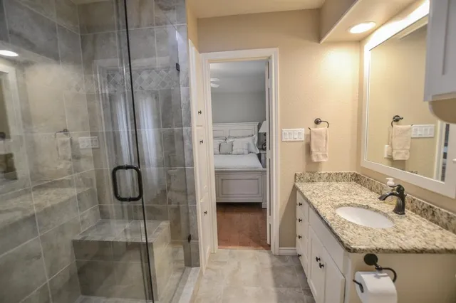 a bathroom with a granite countertop shower mirror and a sink