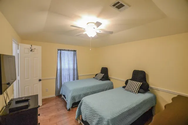 a bedroom with two beds and a chandelier