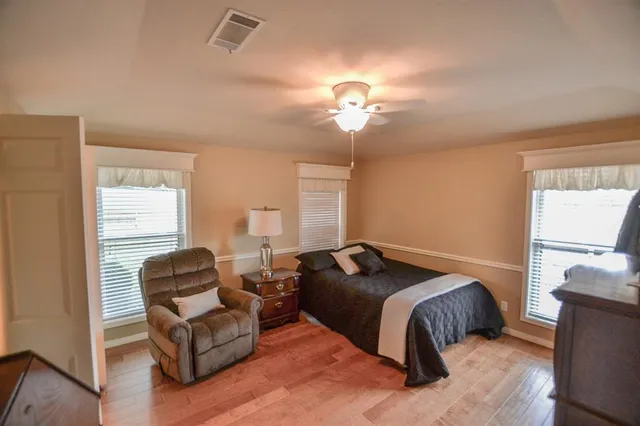 a bedroom with a bed couch chandelier and a window