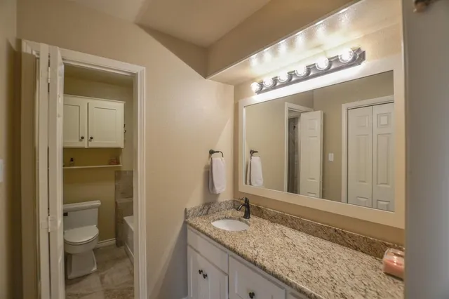 a bathroom with a granite countertop sink and a mirror